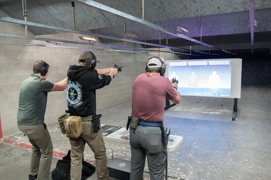 3 men shooting at a digital target