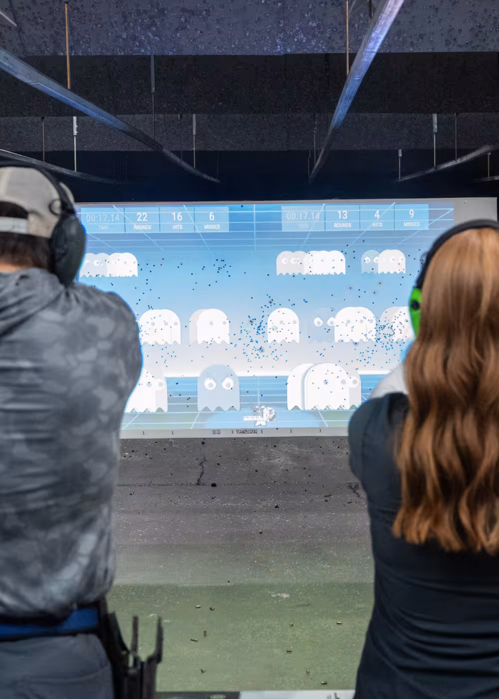 Two people using the Accushoot LFX digital target system at Tactical Penguin shooting range.